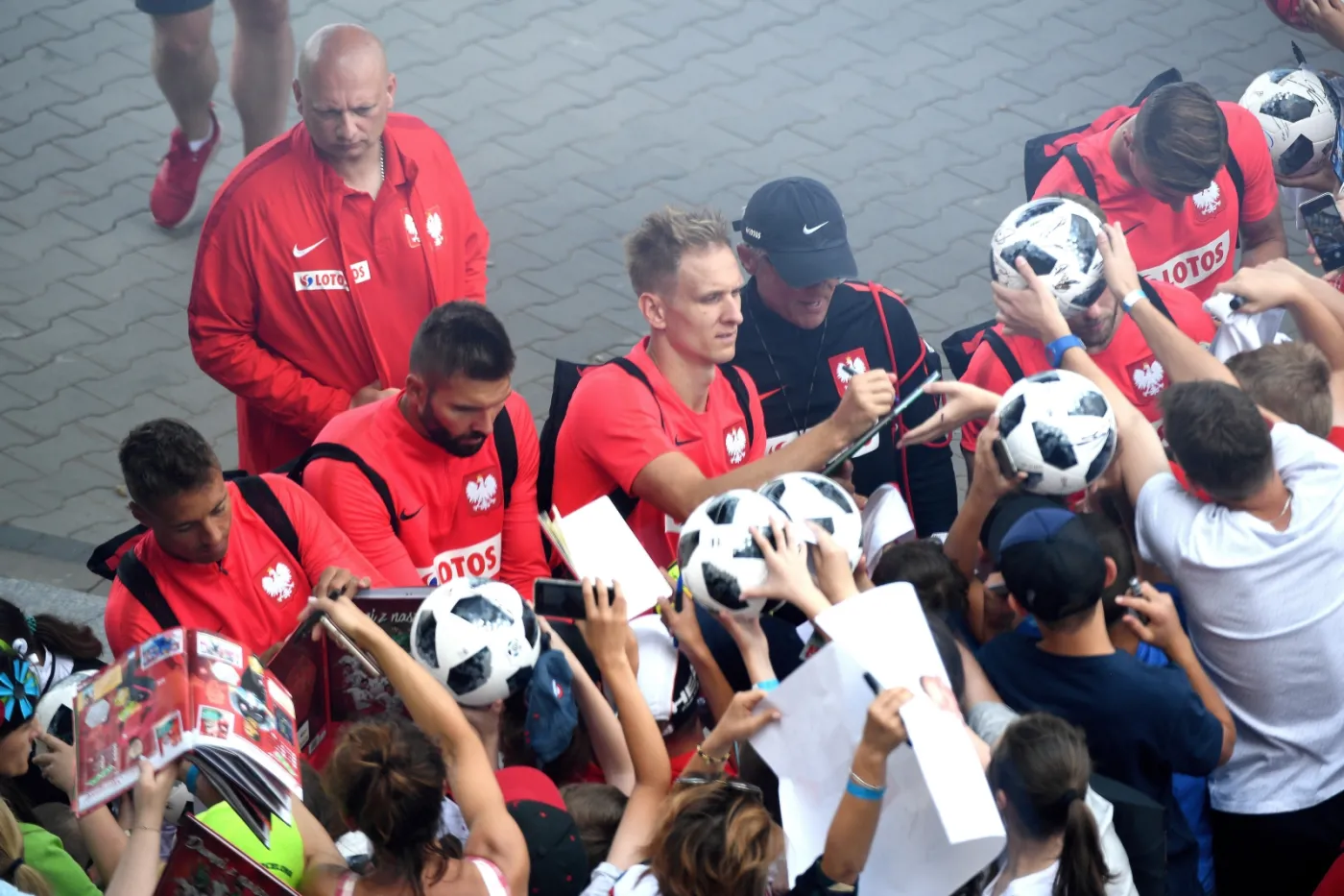 Zawodnicy piłkarskiej reprezentacji Polski rozdają autografy