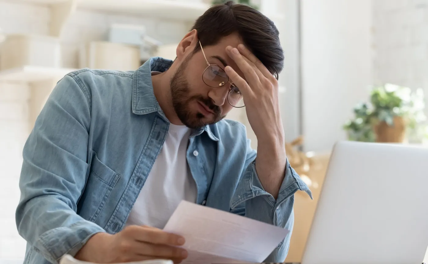 Mężczyzna czytający wezwanie do zapłaty kary za brak ubezpieczenia OC