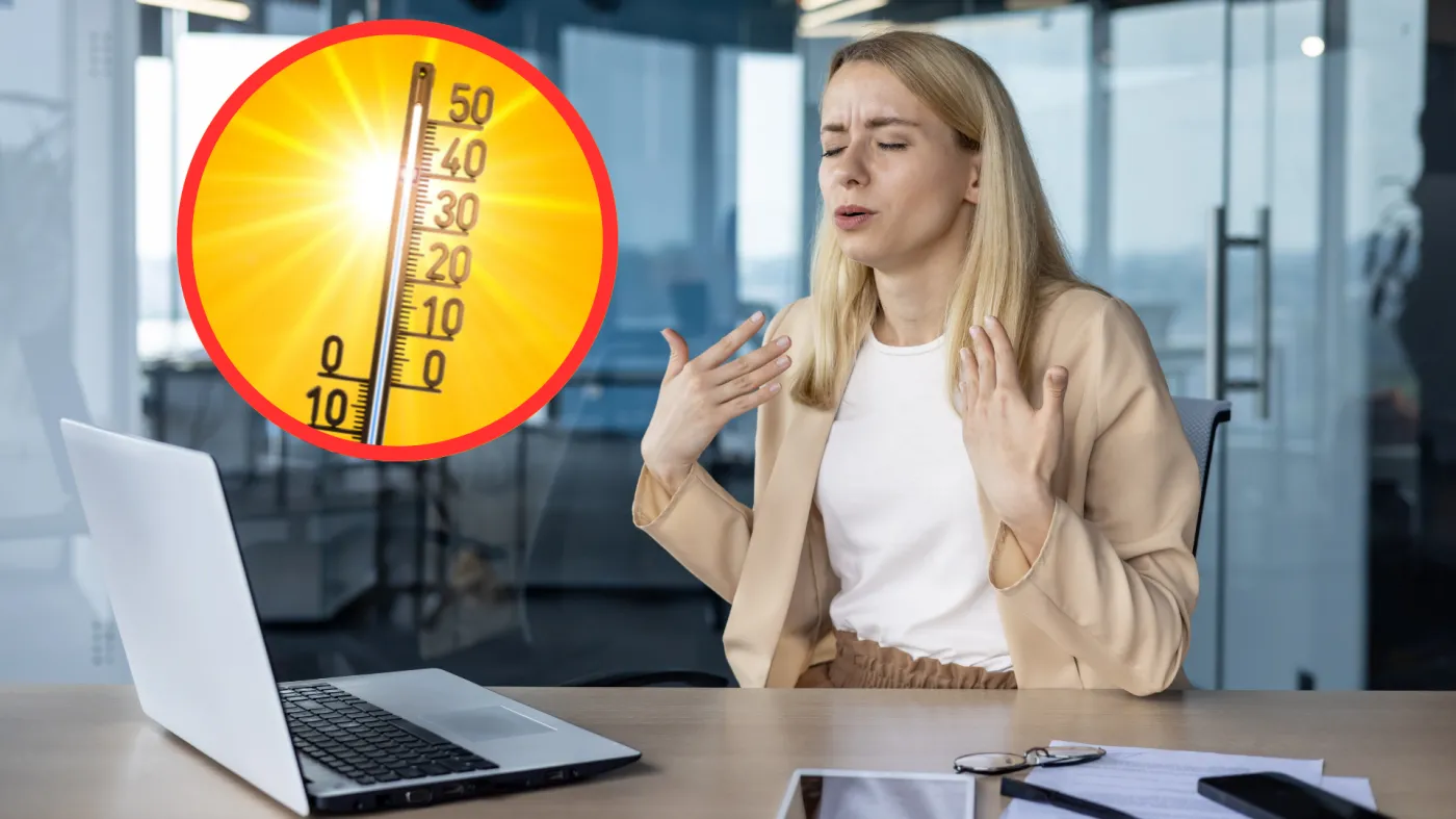 Pracownica w biurze wachluje się dłońmi. W tle termometr wskazujący upał