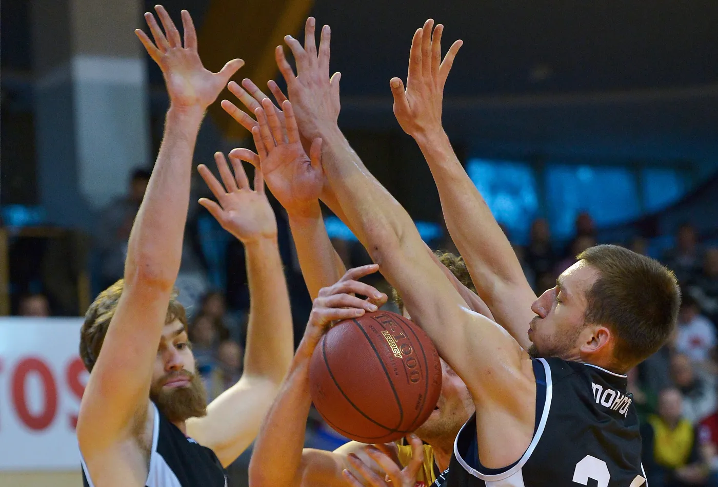 Koszykarz Trefla Sopot Paweł Leończyk (C) pomiędzy Garrettem Stutzem (L) i Jarosławem Mokrosem (P) z Energi Czarni Słupsk
