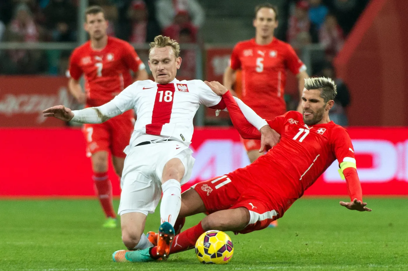 W pojedynku o piłkę gracz reprezentacji Polski Sebastian Mila (L) i Szwajcar Valon Behrami (C) w towarzyskim meczu piłkarskim we Wrocławiu