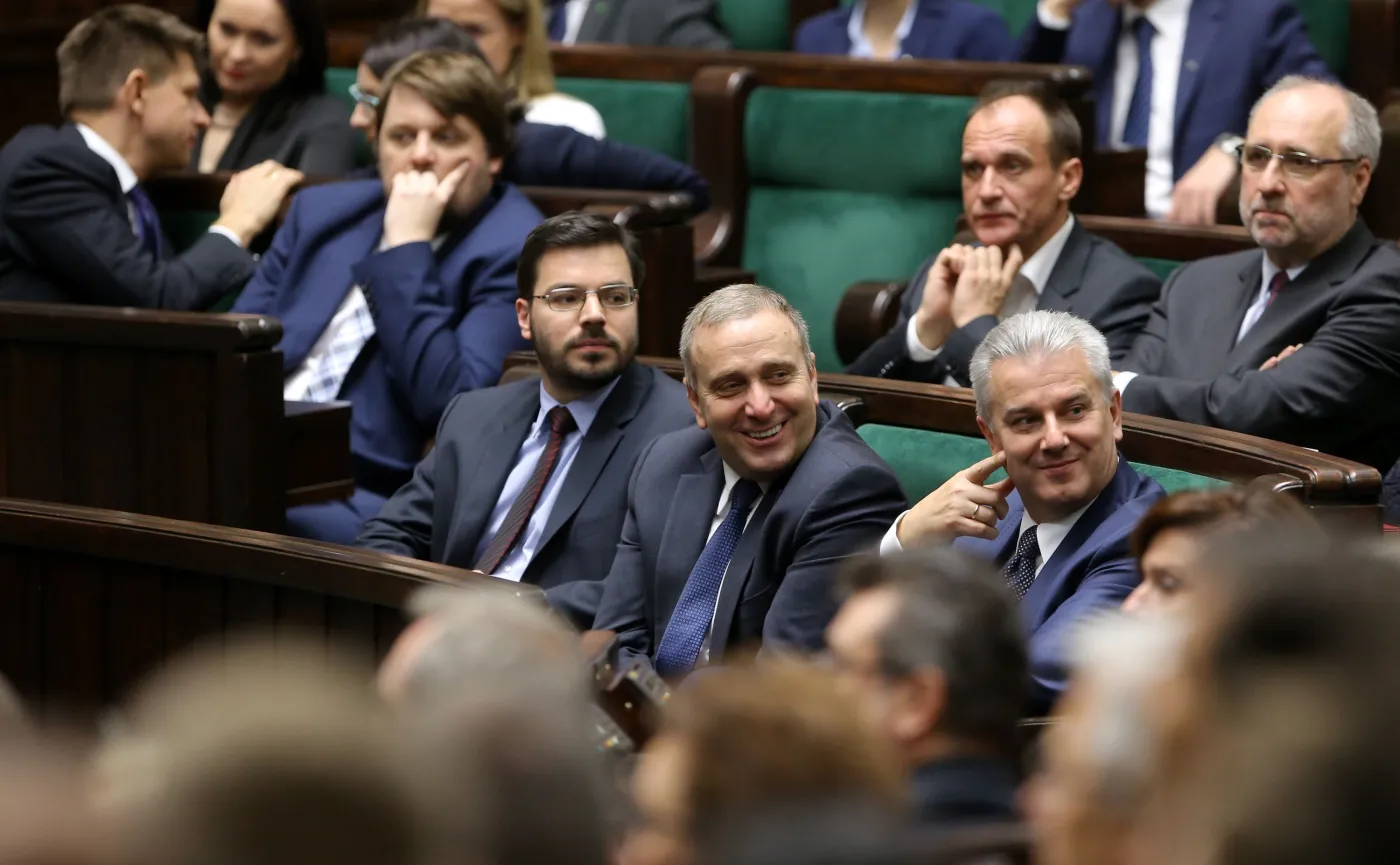 Grzegorz Schetyna i Cezary Grabarczyk z uśmiechem przysłuchują się obradom Sejmu