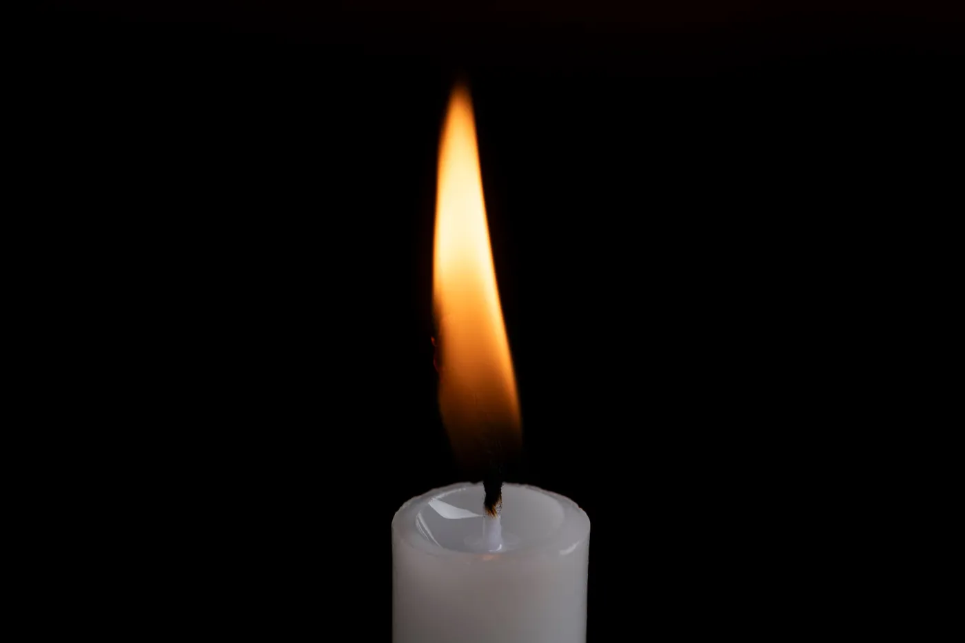 A,Candle,Flame,Glowing,Against,A,Dark,Background
