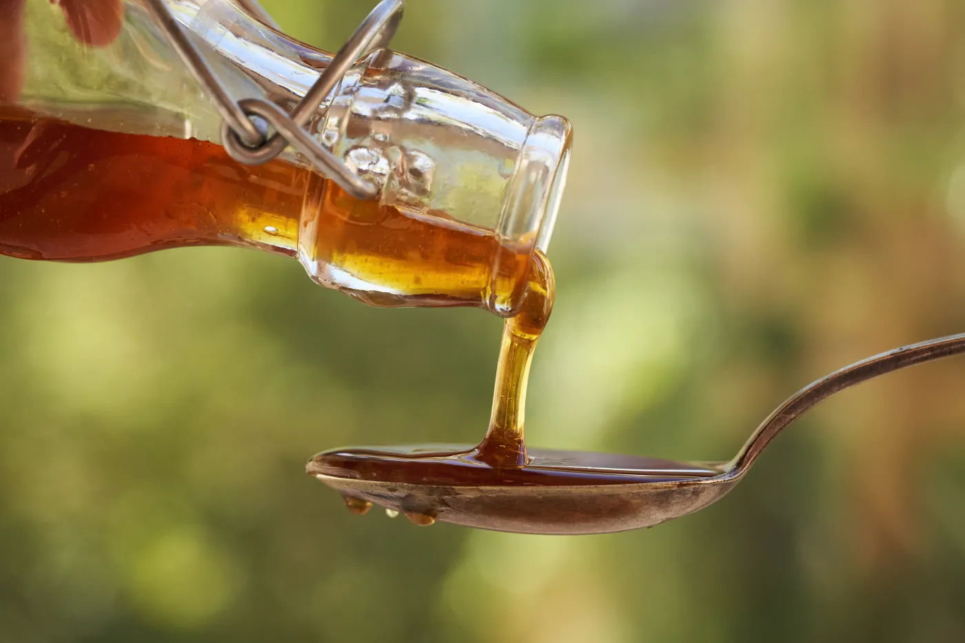 Pouring,Herbal,Syrup,From,A,Glass,Bottle,Onto,A,Metal