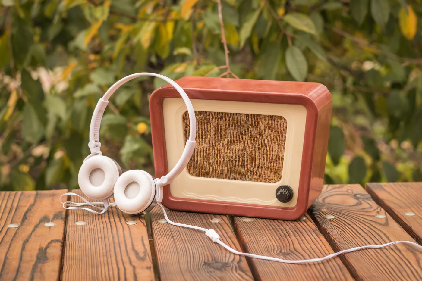 White,Headphones,Near,An,Old-fashioned,Radio,On,An,Autumn,Background.