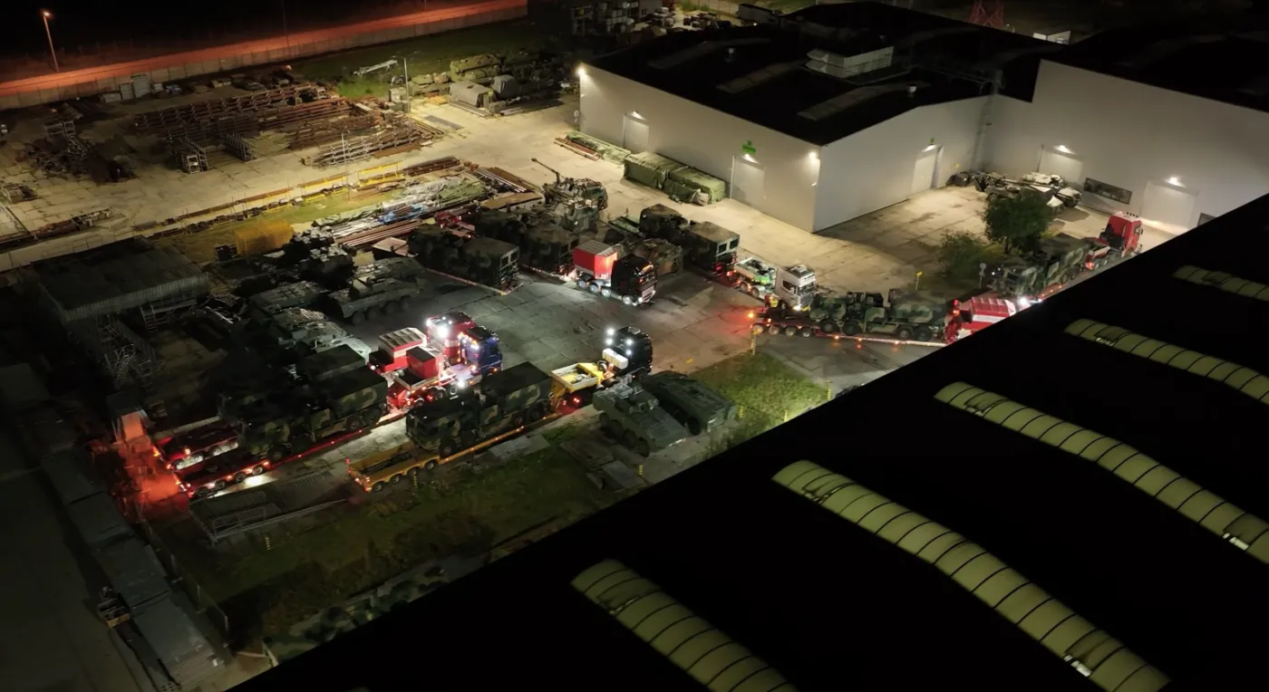 Kadr z filmu promocyjnego HSW, na którym widzimy zgromadzone na placu przed zakładami pojazdy wojskowe. Dostrzec możemy wyrzutnie K-239 Chunmoo (Homar-K), Rosomaki z wieżą ZSSW-30 czy armatohaubice samobieżne Krab.