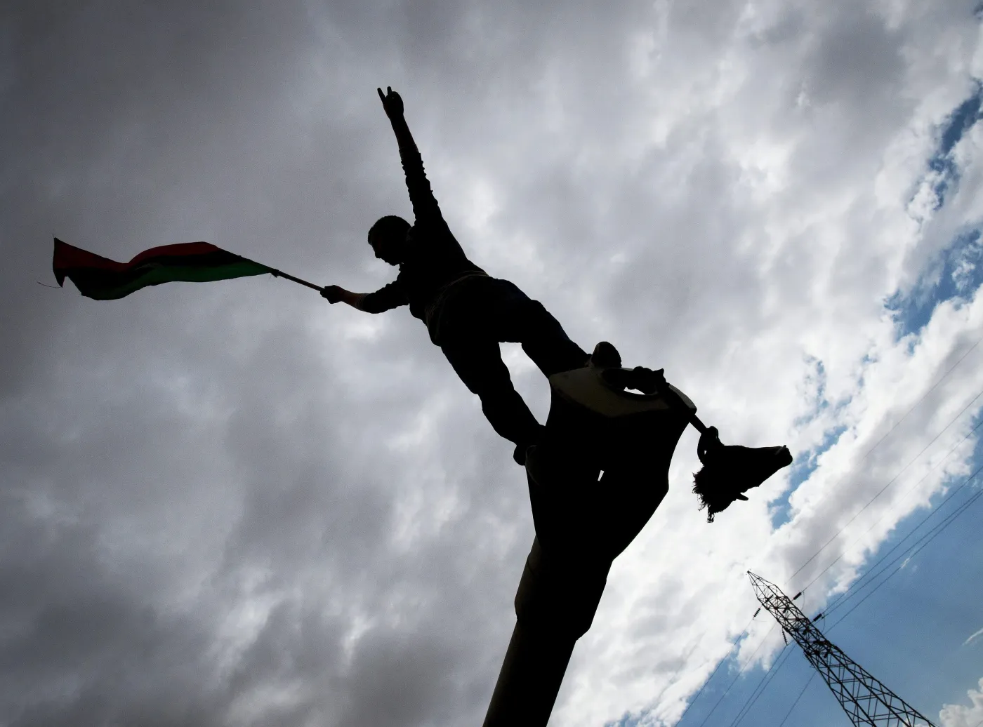 Rebeliant na spalonym czołgu, należącym do sił Muammara Kadafiego, zniszczonym podczas francuskiego nalotu 25 km od Bengazi