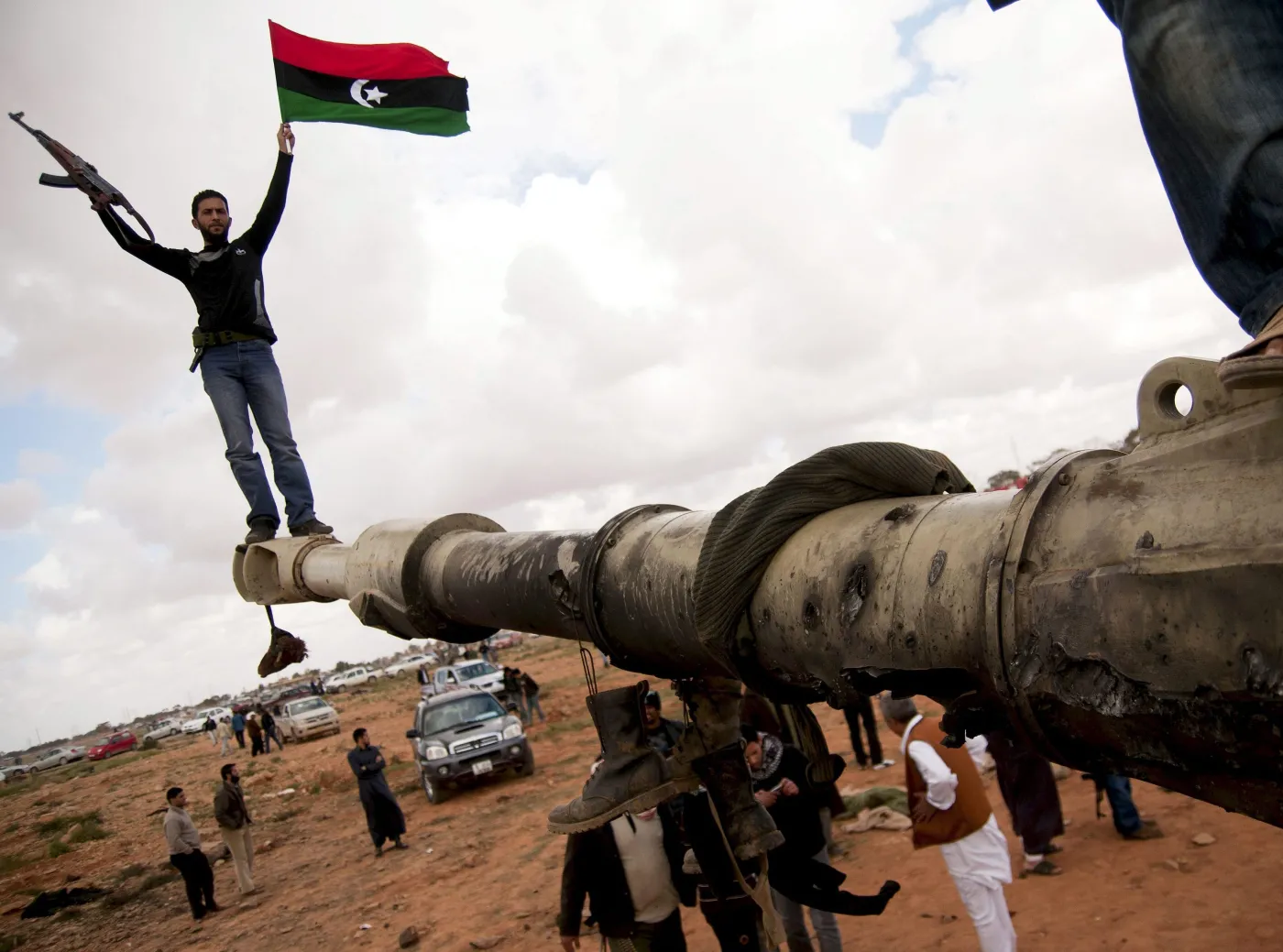 Rebelianci na spalonym czołgu, należącym do sił Muammara Kadafiego, zniszczonym podczas francuskiego nalotu 25 km od Bengazi