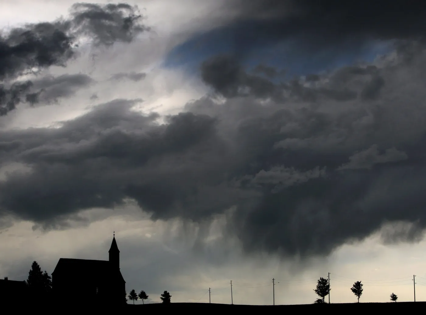 Burzowe chmury nad kościołem w Goerwangs w Niemczech. Alpejskie stoki zostały nie tylko zalane przez gwałtowny deszcz - spadł także grad