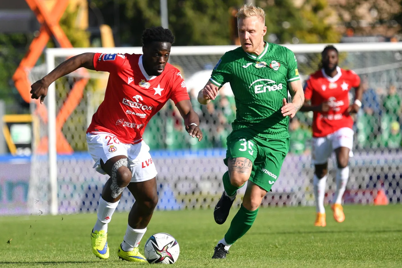 Zawodnik Radomiaka Radom Daniel Łukasik (C) i Elvis Manu (L) z Wisły Kraków podczas meczu 33. kolejki piłkarskiej Ekstraklasy