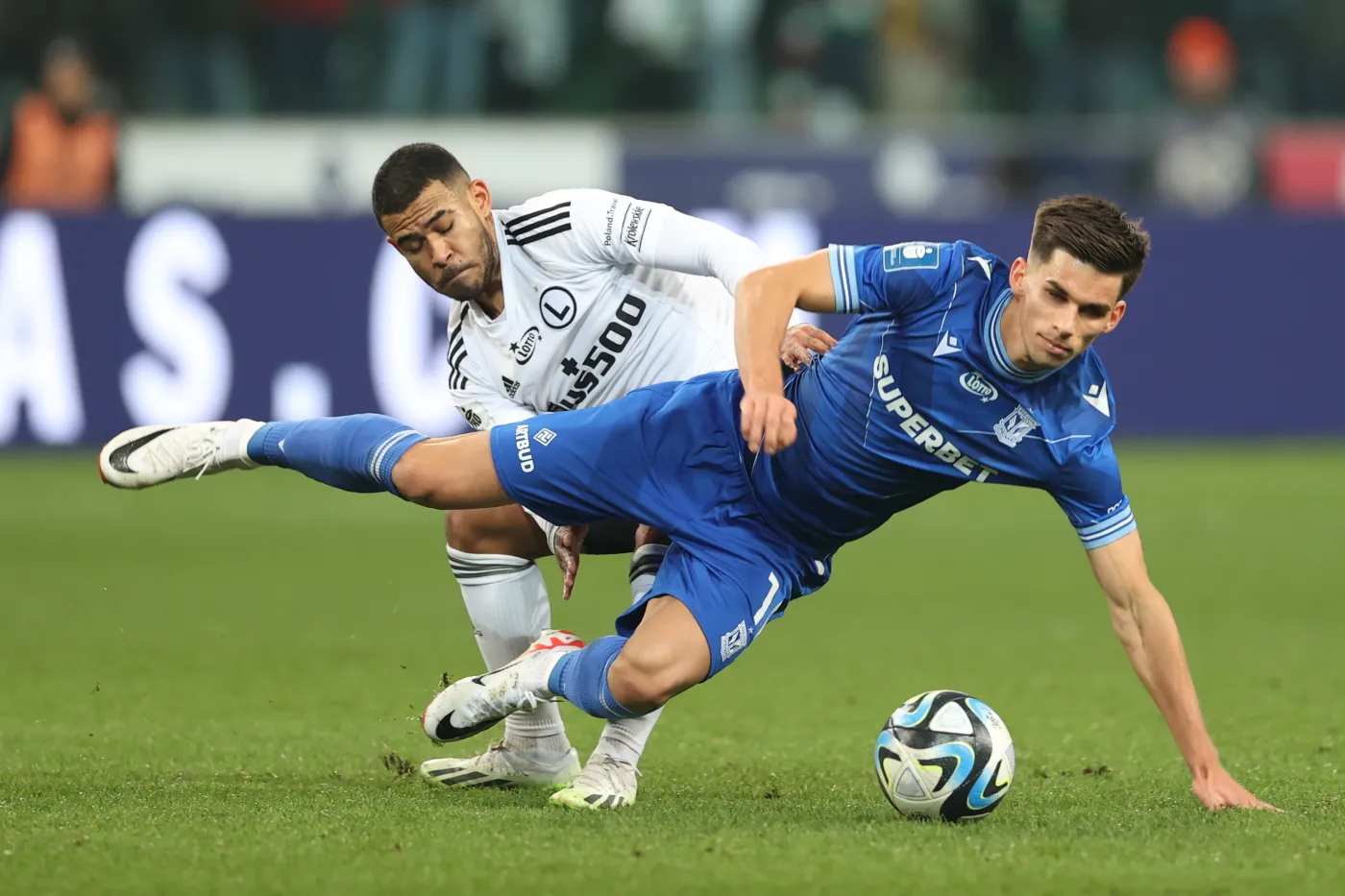 Piłkarz Legii Warszawa Juergen Elitim (tył) i Filip Marchwiński (przód) z Lecha Poznań podczas meczu Ekstraklasy