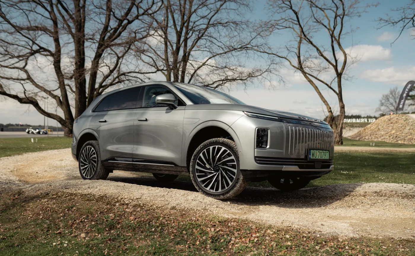 Srebrny SUV Exlantix ET testowany na wzniesieniu podczas jazd próbnych na torze, widok na profil auta i duże felgi