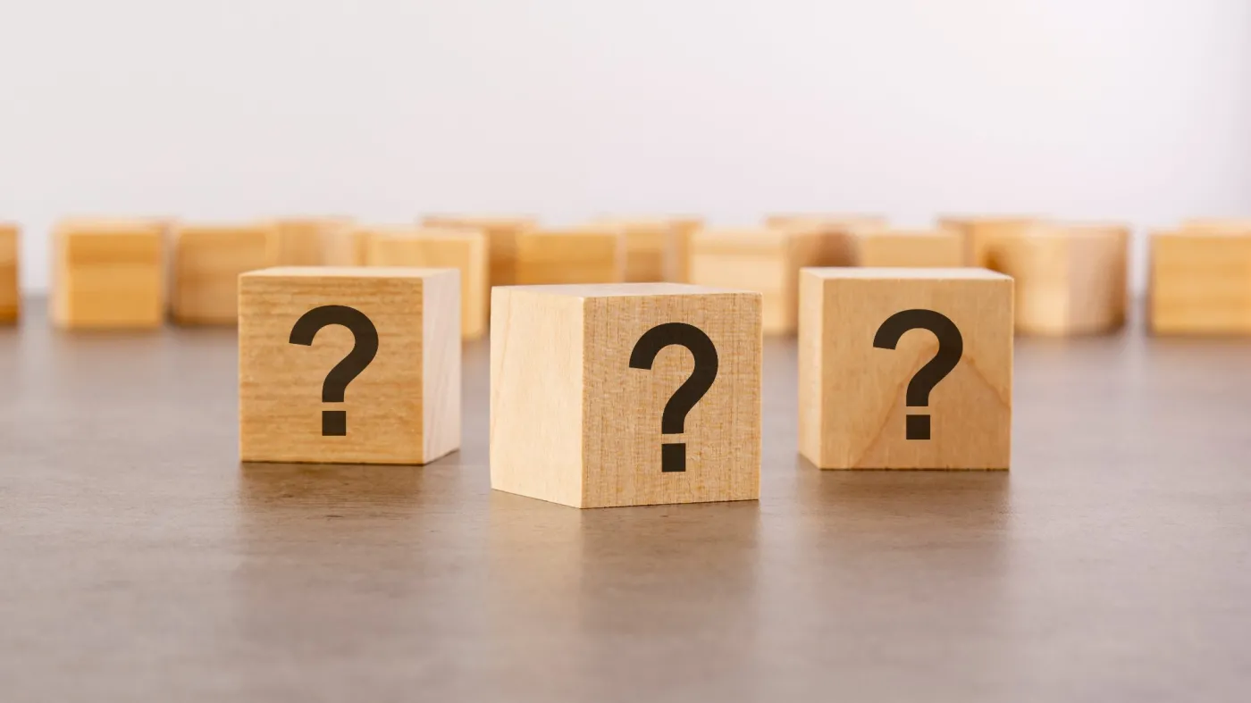 Three,Wooden,Blocks,With,Question,Marks,On,Wooden,Table,,Closeup.