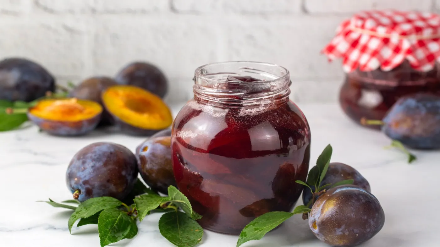 Homemade,Purple,Plum,Jam,In,An,Open,Glass,Jar,Surrounded