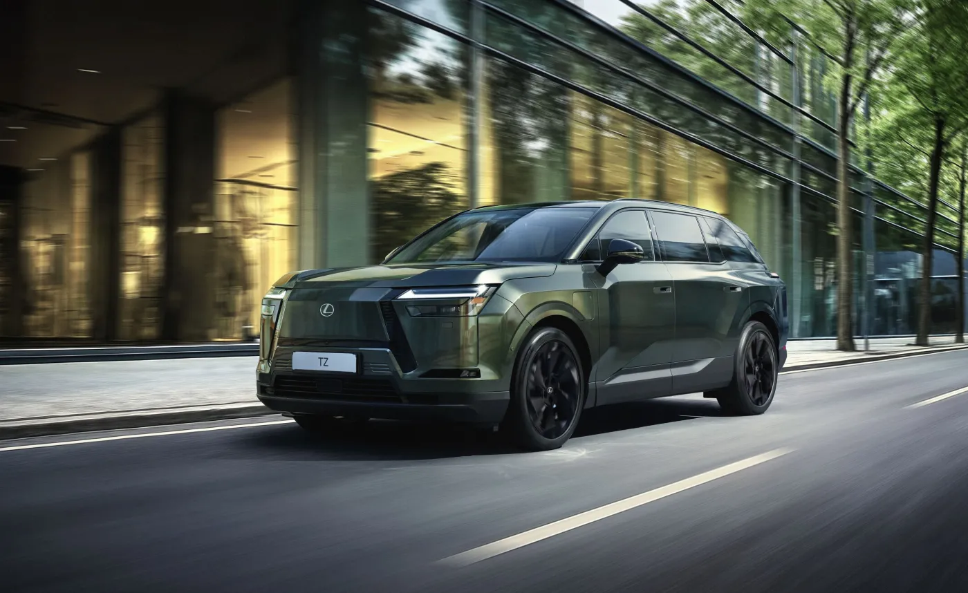 Zielony elektryczny SUV Lexus TZ jedzie miejską ulicą na tle nowoczesnych biurowców