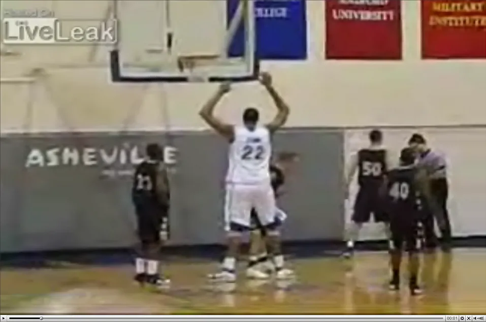 Wkłada piłkę do kosza, nie odrywając stóp od ziemi