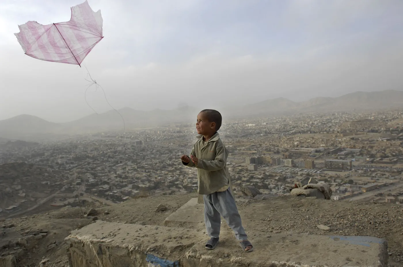 05.10.2007 Kabul Afganistan Maly chlopiec puszcza latawca zrobionego z foliowej torby na wzgorzu gorujacym nad Kabulem . Na zboczach Television Hill w glinianych chatach mieszka biedota fot. Pawel Ulatowski