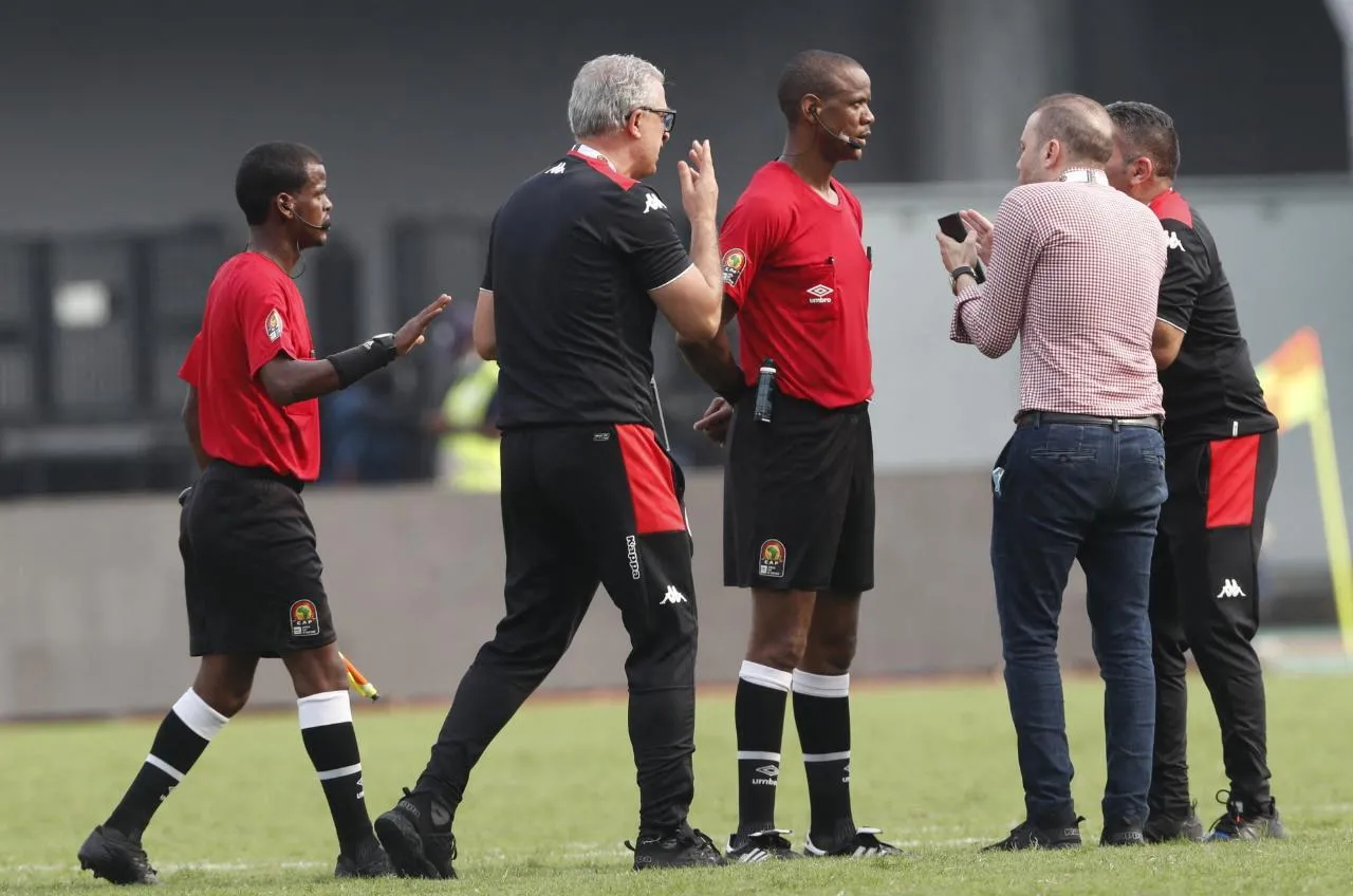 Kierownik reprezentacji Tunezji Hussein Jenayah w rozmowie z zambijskim sędzią Jannym Sikazwem podczas meczu Tunezja - Mali