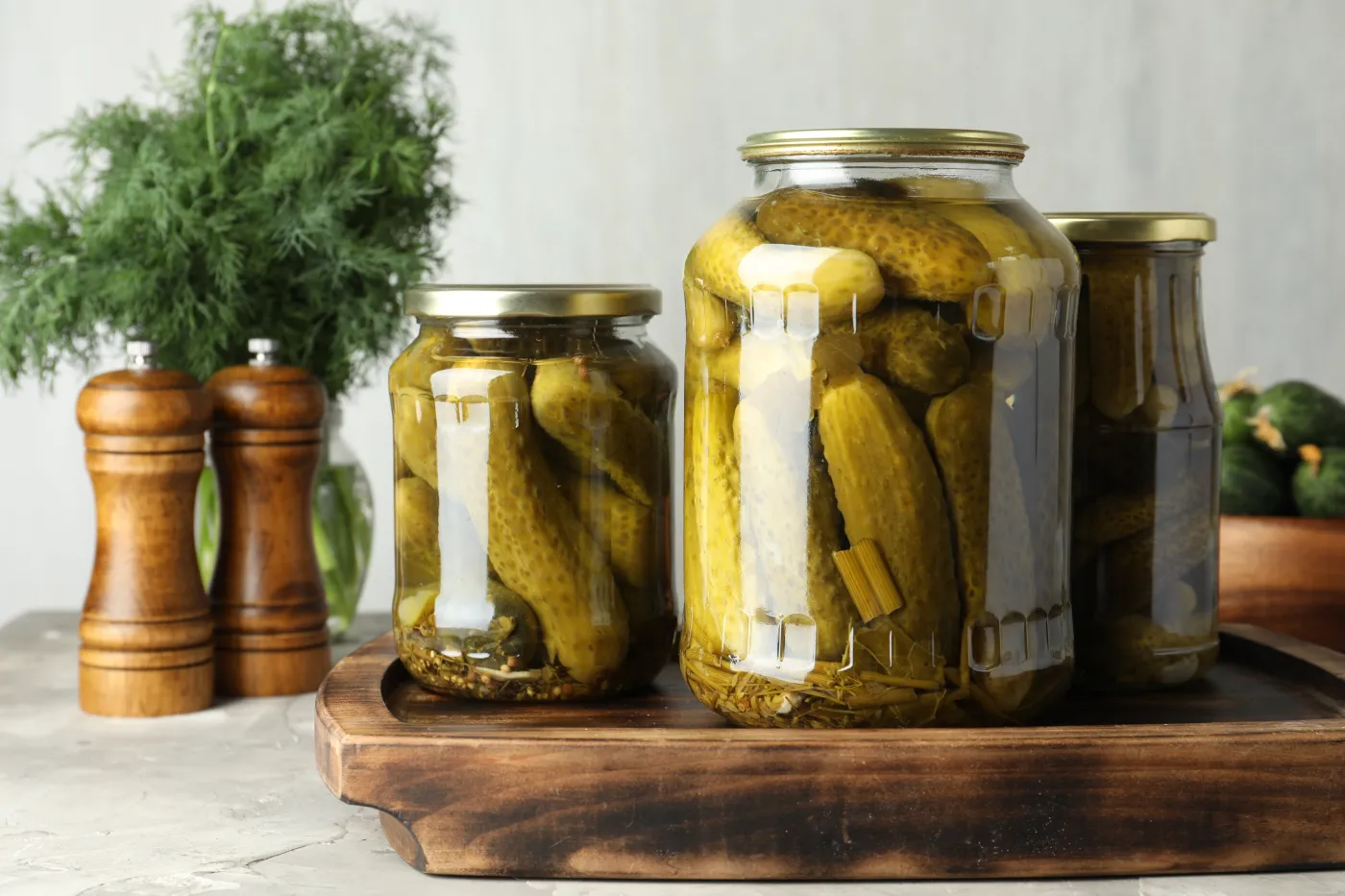 Pickled,Cucumbers,In,Jars,On,Grey,Table