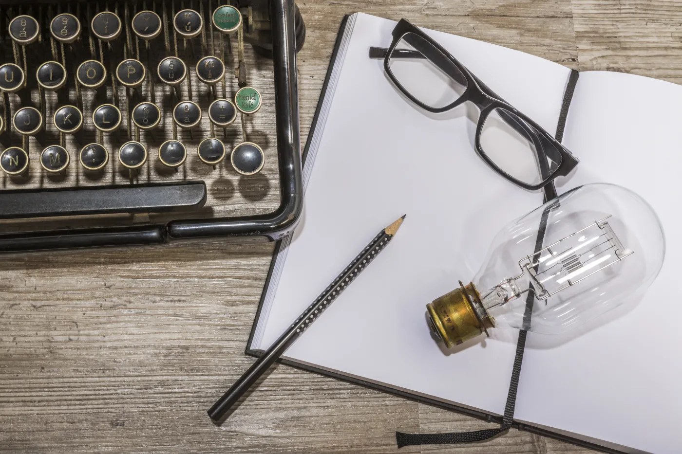 Blank,Book,,Antique,Typewriter,With,Reading,Glasses,And,A,Light