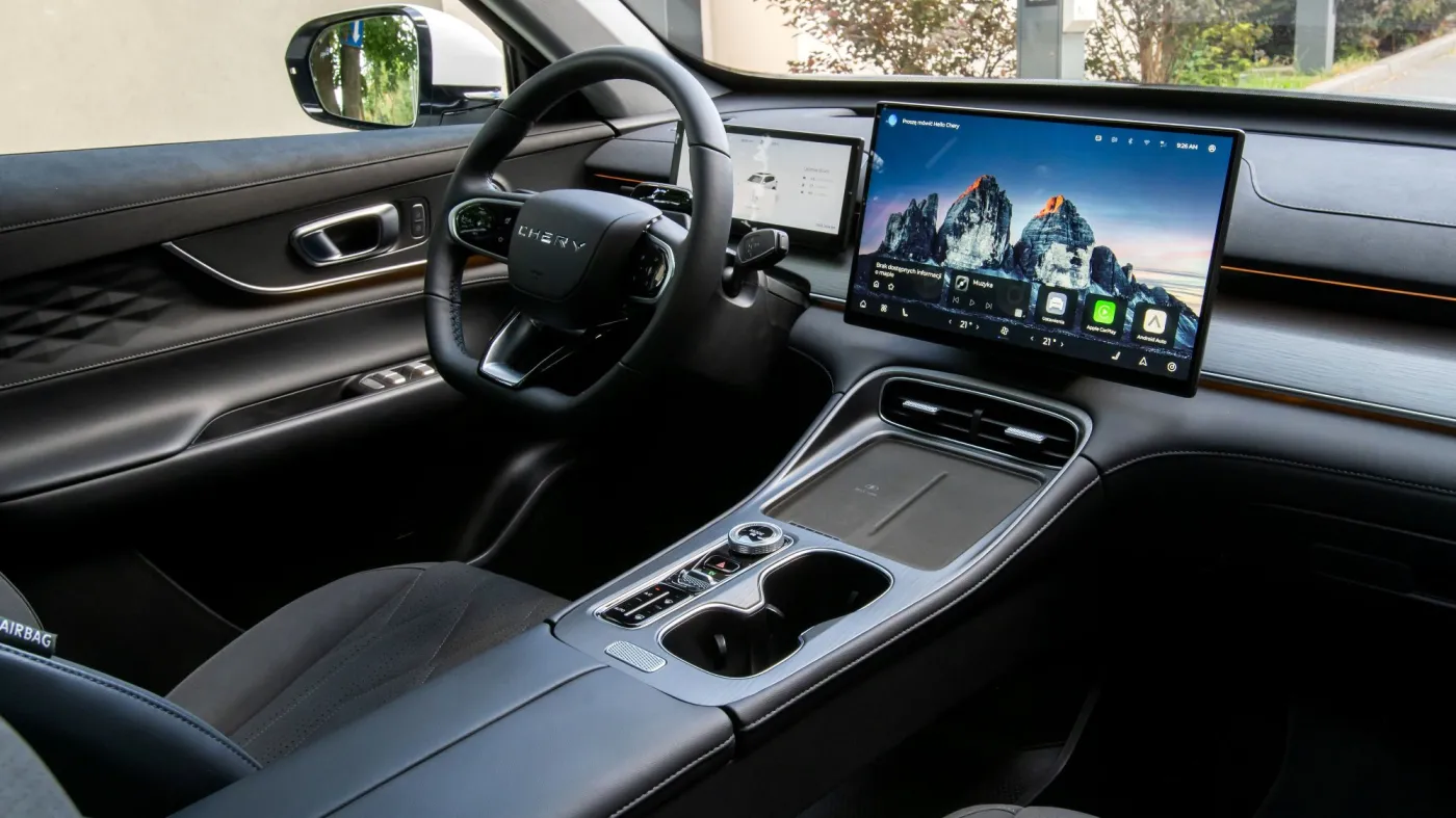 Wnętrze chińskiego samochodu marki Chery Tiggo 8 PHEV z dużym centralnym ekranem multimedialnym i skórzaną kierownicą