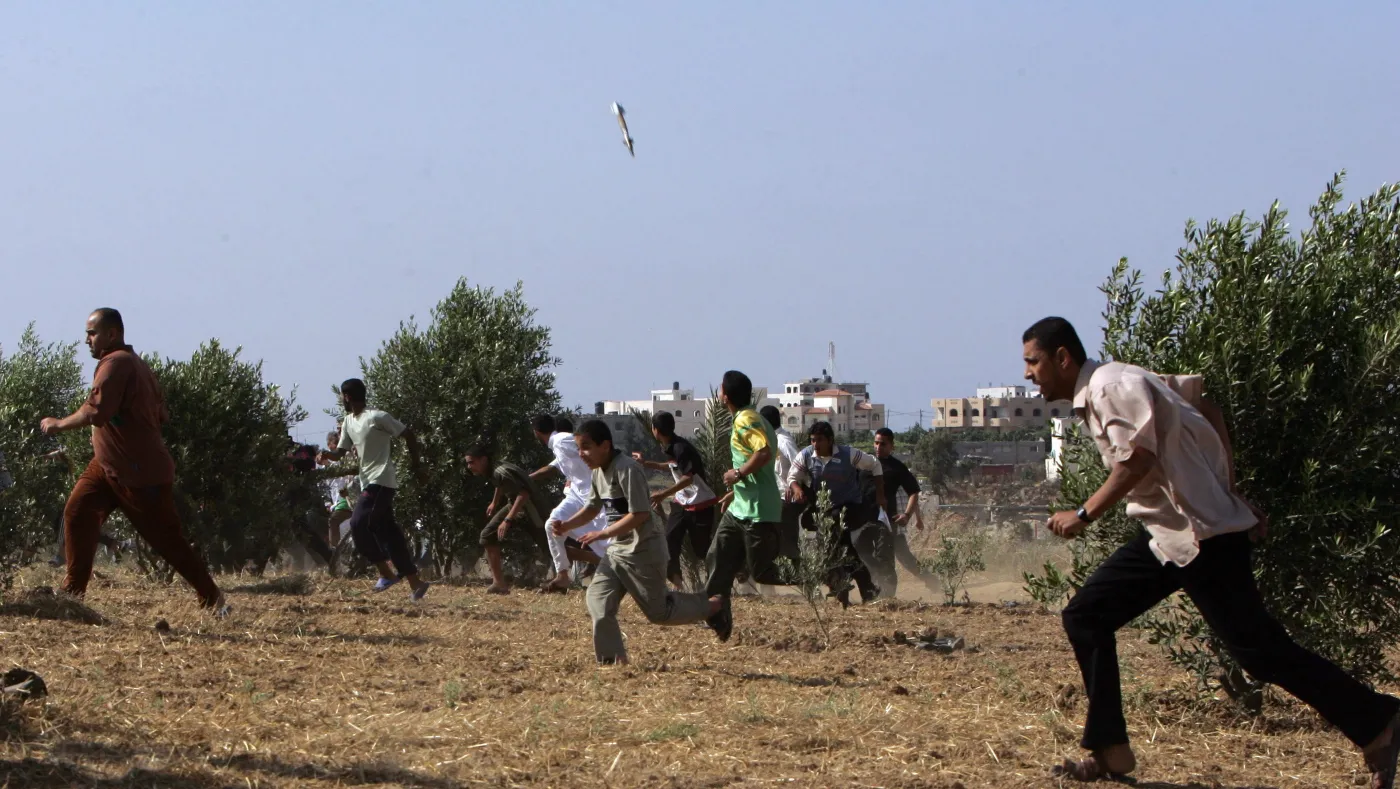 TO GO WITH AFP STORY YEAR-2007-MIDEAST
FILES Palestinians run for cover as a rocket C falls from the sky during an Israeli air strike on a Hamas Executive Force building in Nusseirat refugee camp in the centre of the Gaza strip, 25 May 2007. Warplanes pounded the Gaza Strip for a ninth day today as Palestinians continued to fire rockets into Israel despite a call from Palestinian president Mahmud Abbas for a truce. AFP PHOTOMAHMUD HAMS