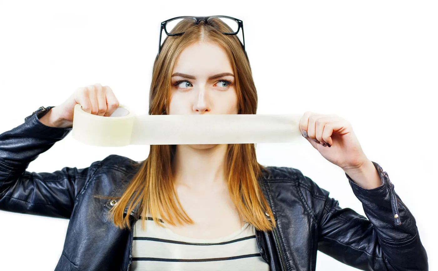 Kobieta zakleja usta. Mouth taping