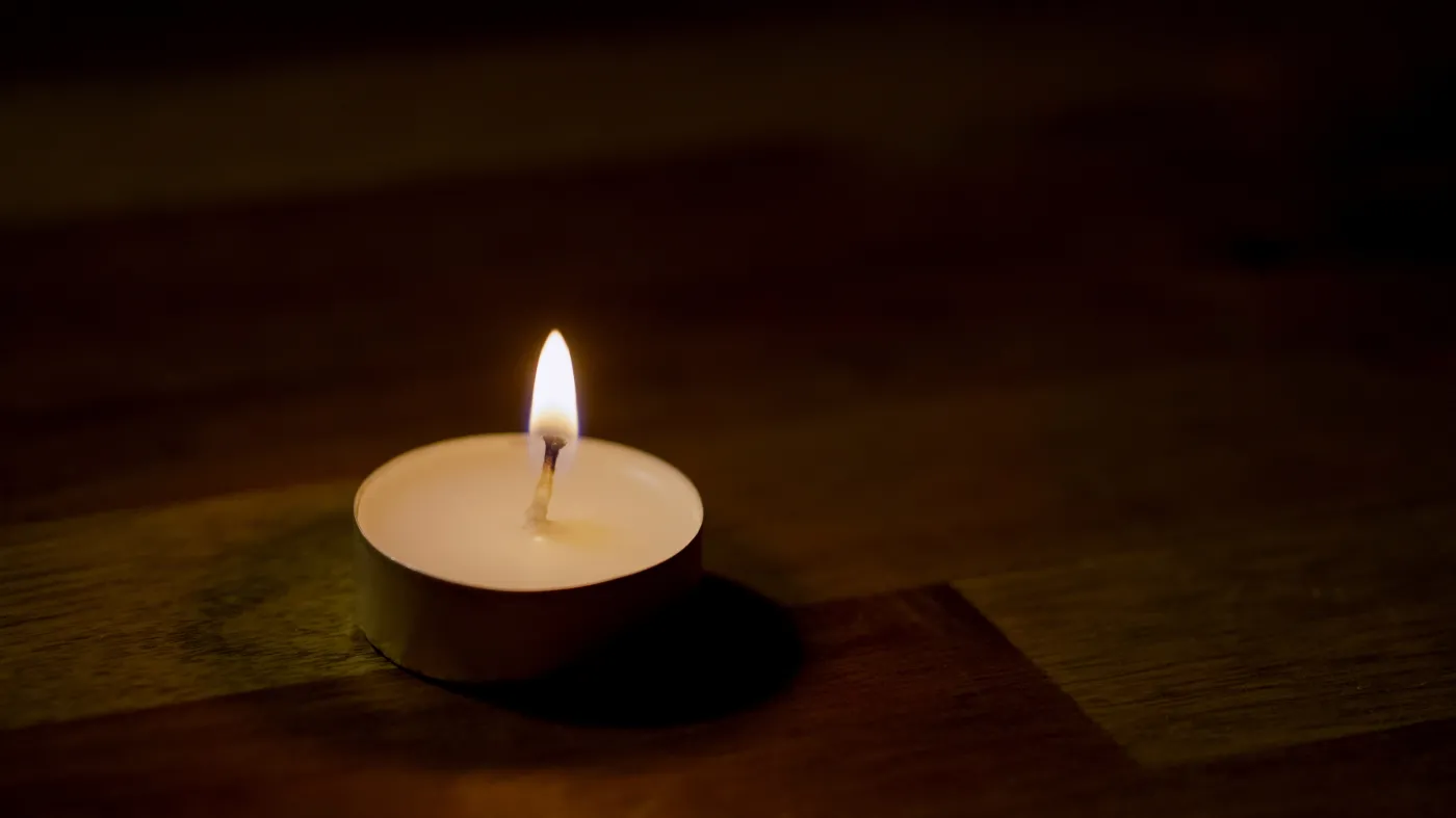 A,Single,Candle,Flickers,Quietly,On,A,Wooden,Table,,Casting