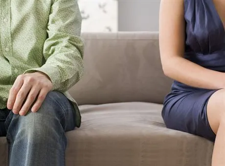 Mid section view of a man and a woman sitting on a couch