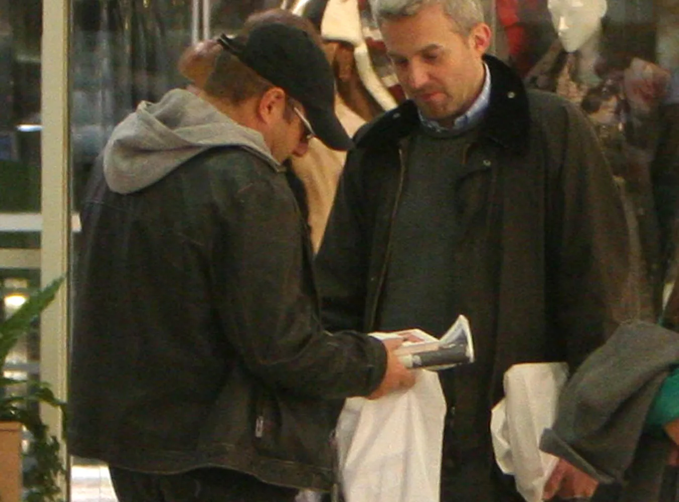 Piotr Gąsowski i Hubert Urbański pokazują sobie zakupy