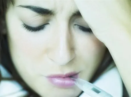 Woman Taking Temperature --- Image by  Ken KamineskyTake 2 ProductionsCorbis