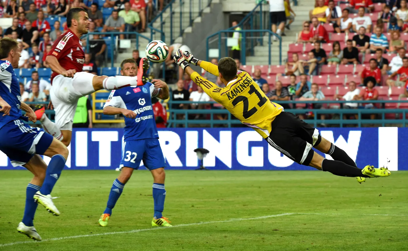 Piłkarz Wisły Kraków Paweł Brożek (L) w ataku na bramkę Krzysztofa Kamińskiego (P) z Ruchu Chorzów podczas meczu polskiej Ekstraklasy