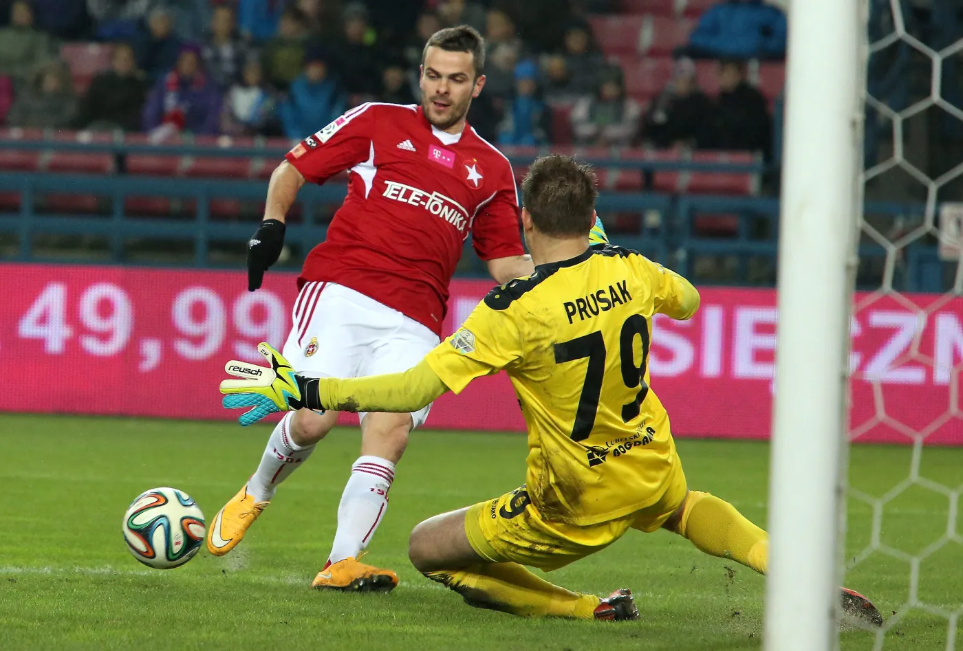 Piłkarz Wisły Kraków Paweł Brożek (L) w ataku na bramkę Sergiusza Prusaka (P) z Górnika Łęczna podczas meczu polskiej Ekstraklasy