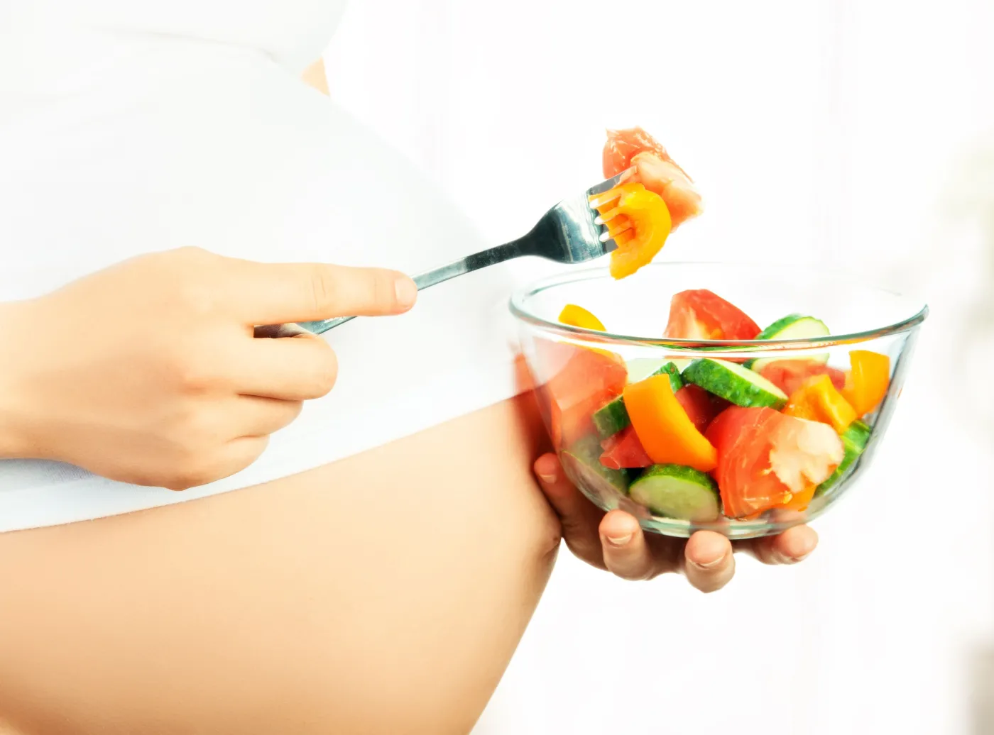 Kobieta w ciąży je sałatkę