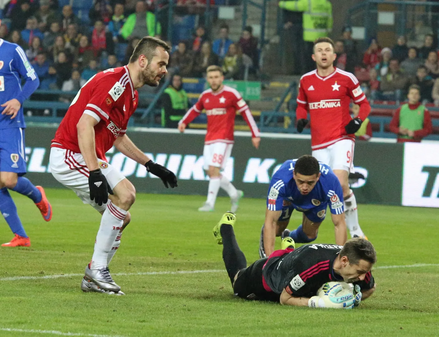 Piłkarz Wisły Kraków Paweł Brożek (L) i bramkarz Jakub Szmatuła (P-na ziemi) z Piasta Gliwice