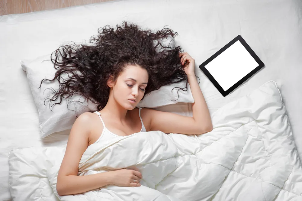 Kobieta śpiąca z tabletem