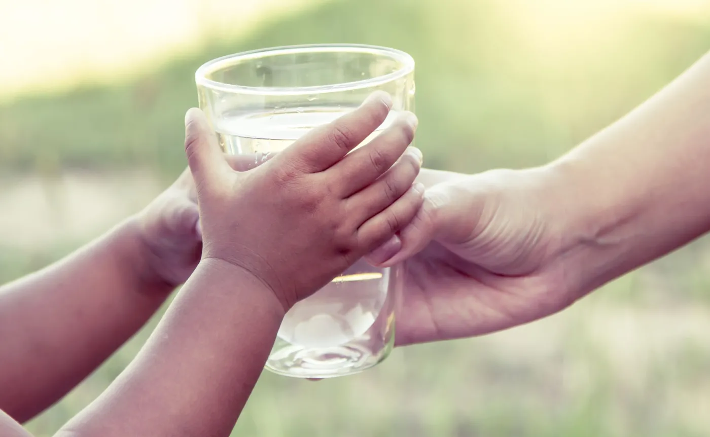 Rodzic podaje dziecku wodę