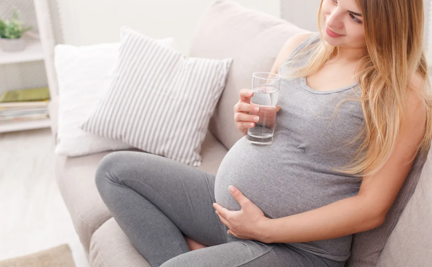 Kobieta w ciąży pije wodę