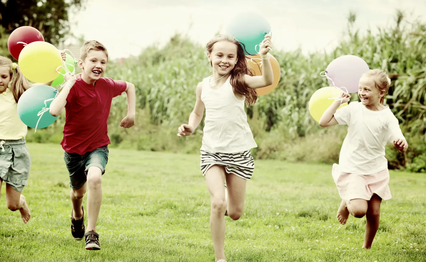 Dzieci biegną z balonami