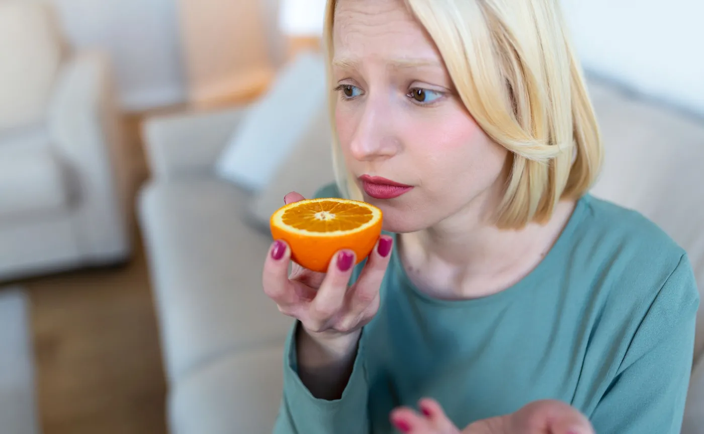 Utrata węchu, kobieta wącha pomarańczę