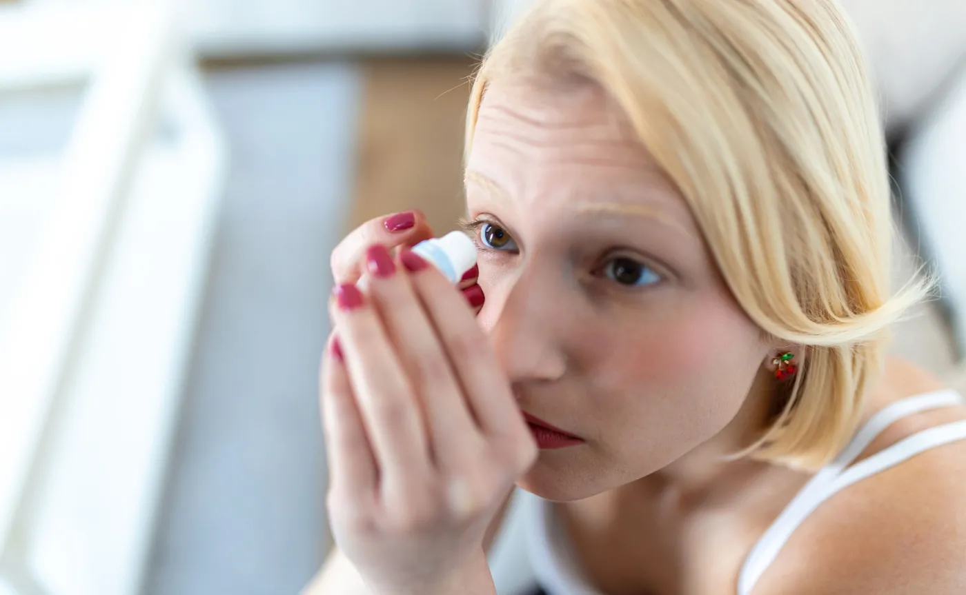 Kobieta zakrapla oko, suche oczy