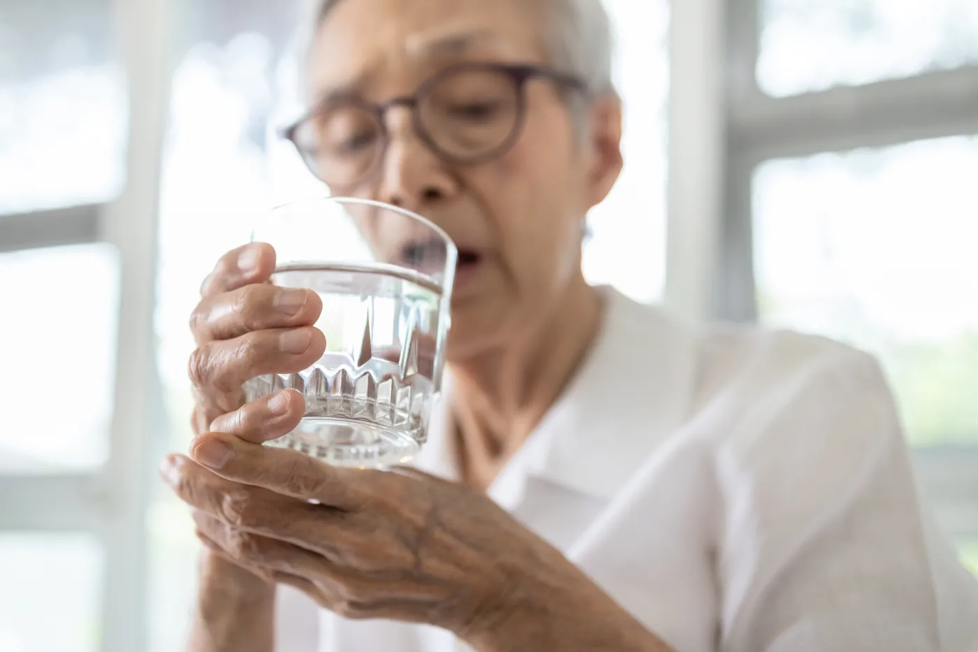 Senior,Woman,Holding,Glass,Of,Water,hand,Shaking,While,Drinking,Water,elderly