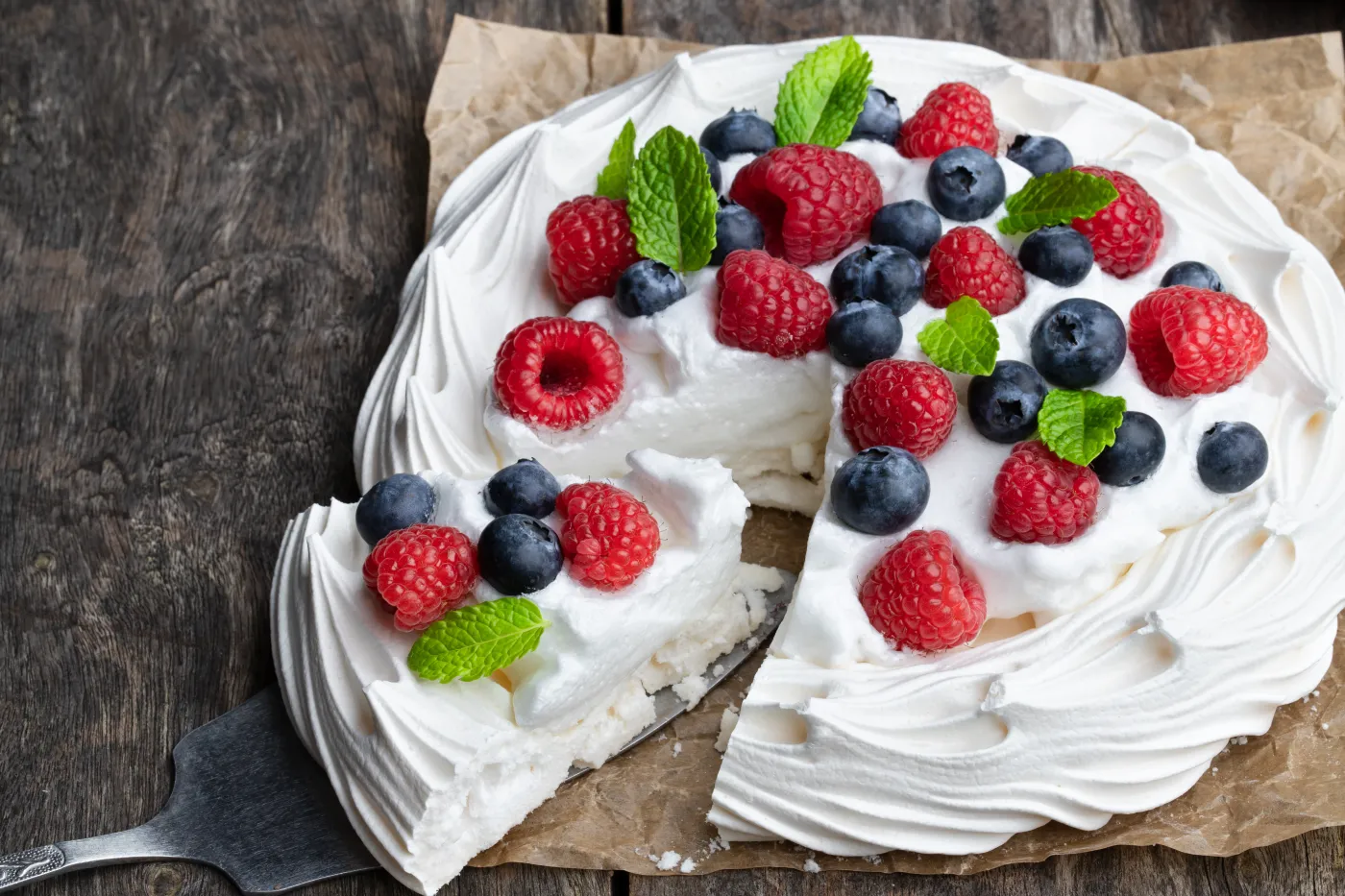 Beza deser Pavlova,Meringue,Nest,With,Berries,And,Mint,Leaves,On,Wooden