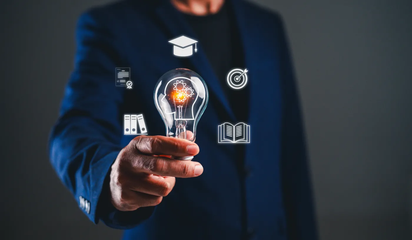 A,Person,Holding,A,Light,Bulb,With,Icons,Representing,Education,