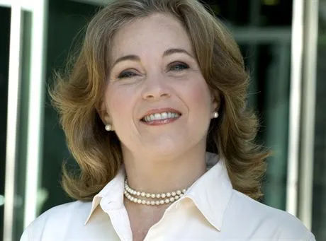 Smiling businesswoman wearing white blouse and pearls --- Image by  MedioImagesCorbis