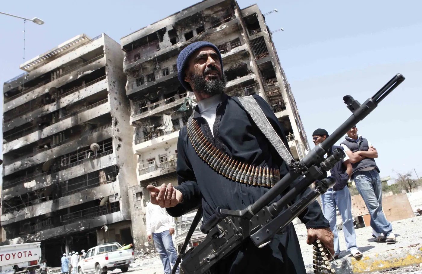 Jeden z rebeliantów z Misraty przed budynkiem zniszczonym przez artylerię Muammara Kadafiego