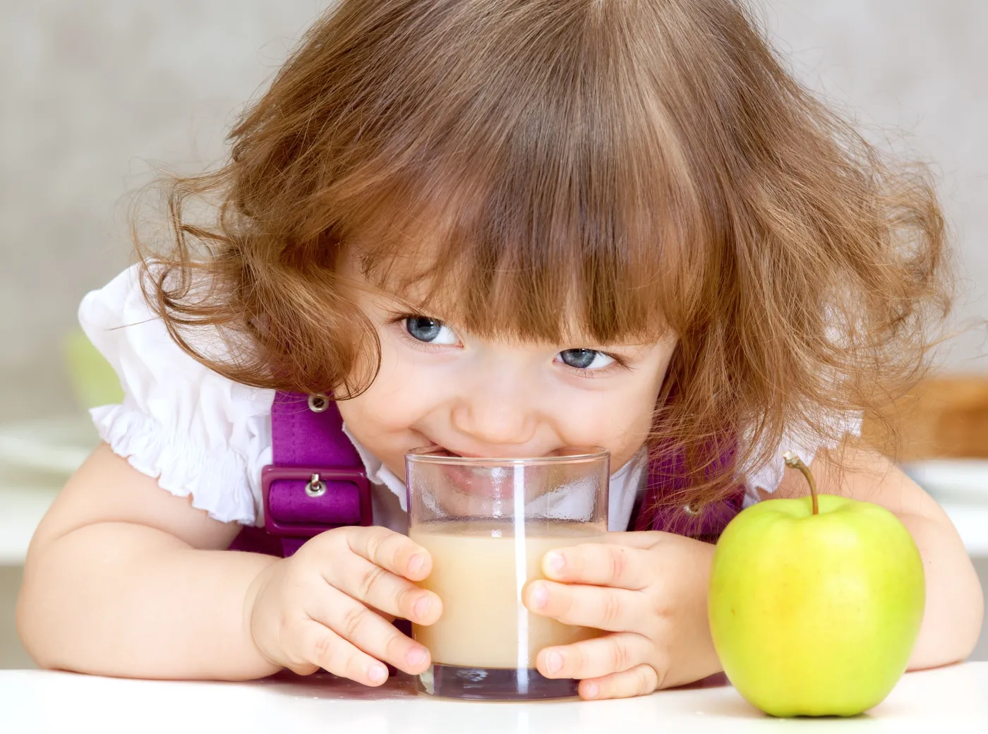 Dziewczynka pije sok jabłkowy