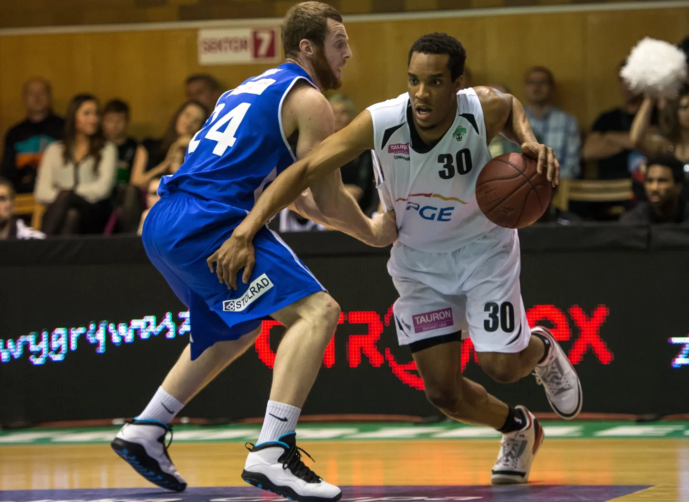 Jakub Dłoniak (L) z Rosy Radom blokuje kozłującego piłkę JP Prince'a z PGE Turów Zgorzelec