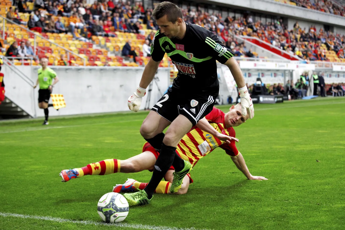 Piłkarz Jagiellonii Białystok Mateusz Piątkowski (z tyłu) w ataku na bramkę Dariusza Treli z Piasta Gliwice podczas meczu grupy B polskiej Ekstraklasy