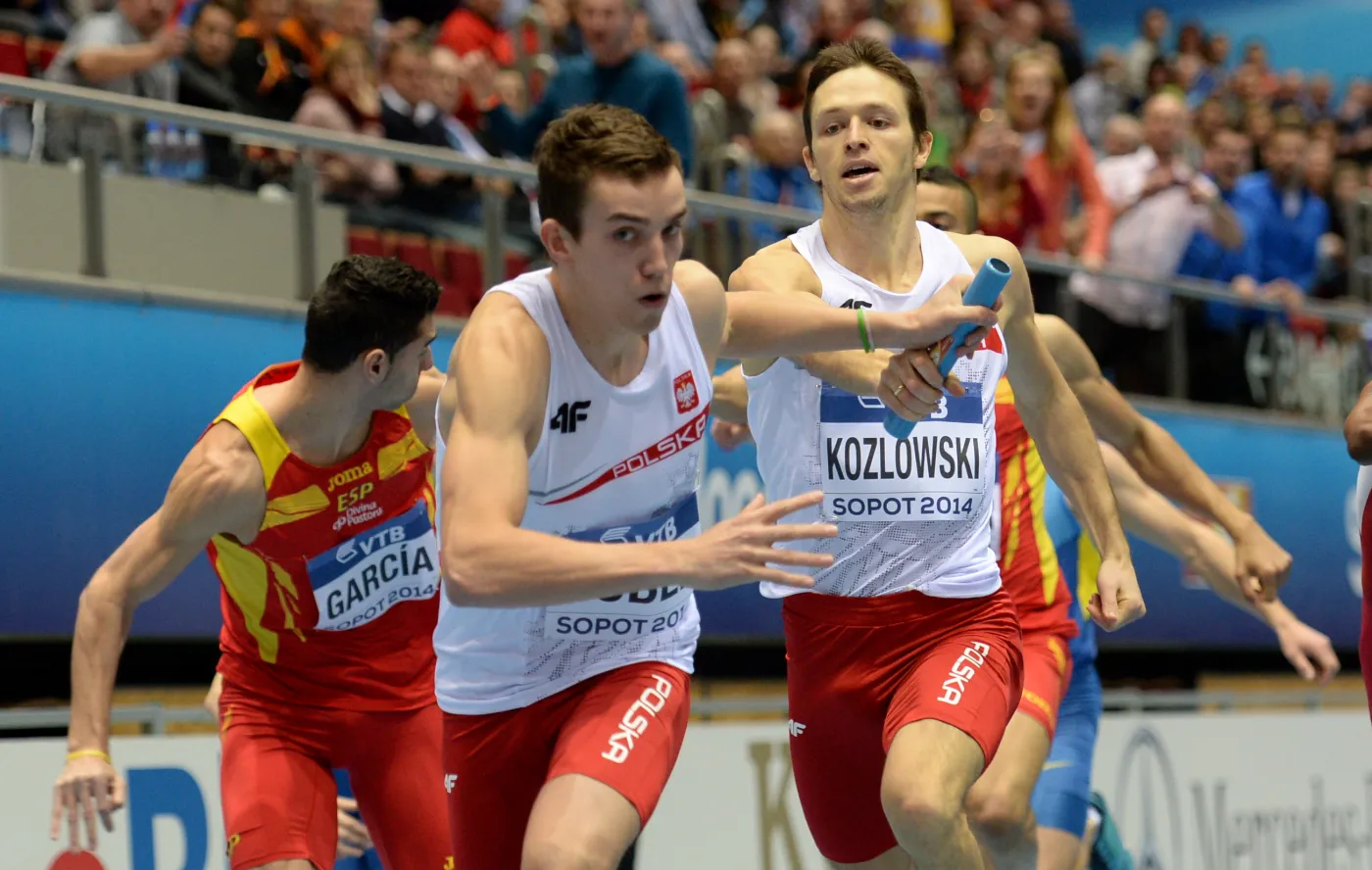 Kacper Kozłowski (P) i Patryk Dobek (L) przekazują sobie pałeczkę w kwalifikacjach sztafety 4x400 m podczas halowych lekkoatletycznych mistrzostw świata w sopockiej Ergo Arenie